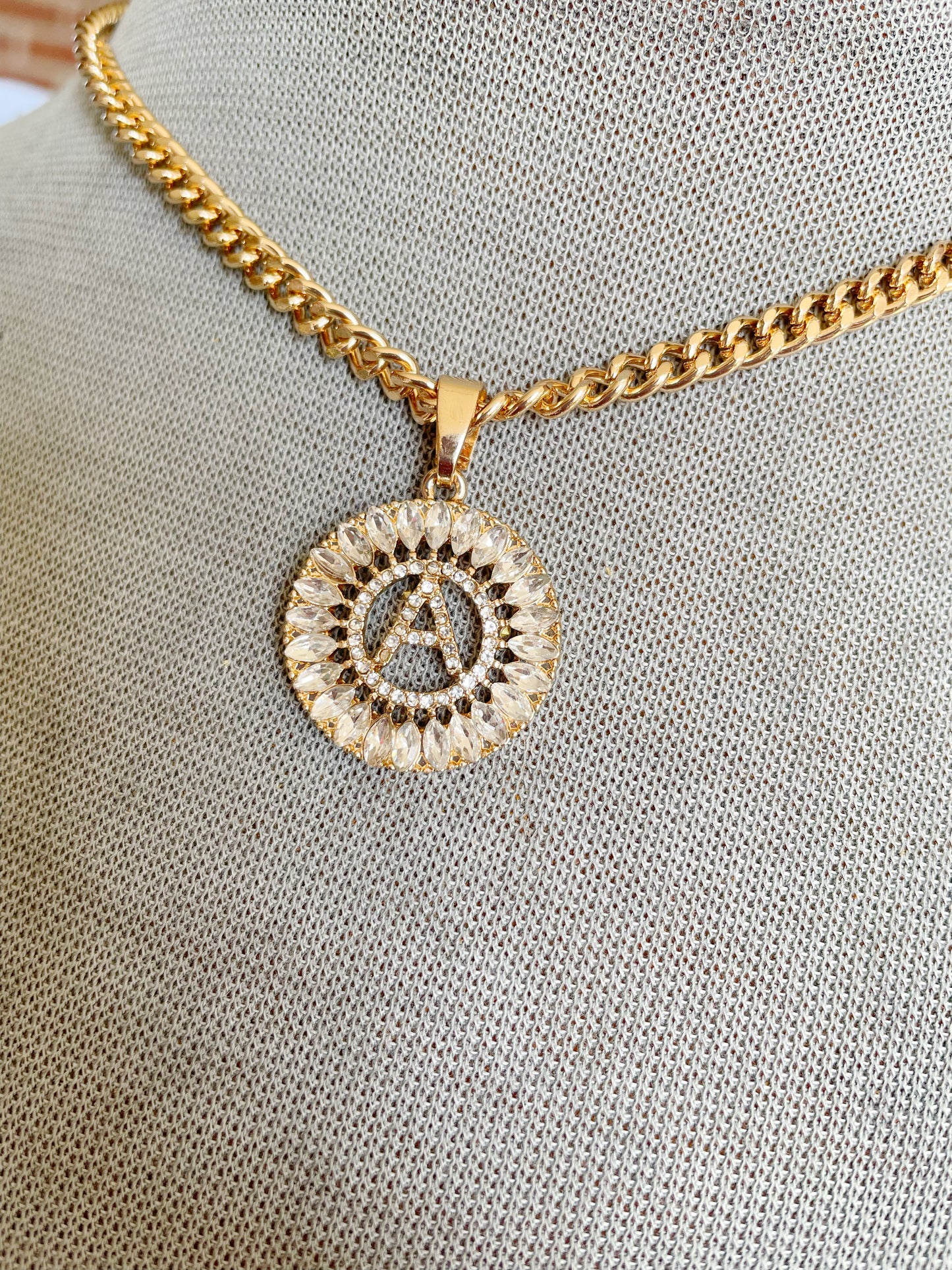 Letter A initial necklace encased in rhinestones on a gold link chain