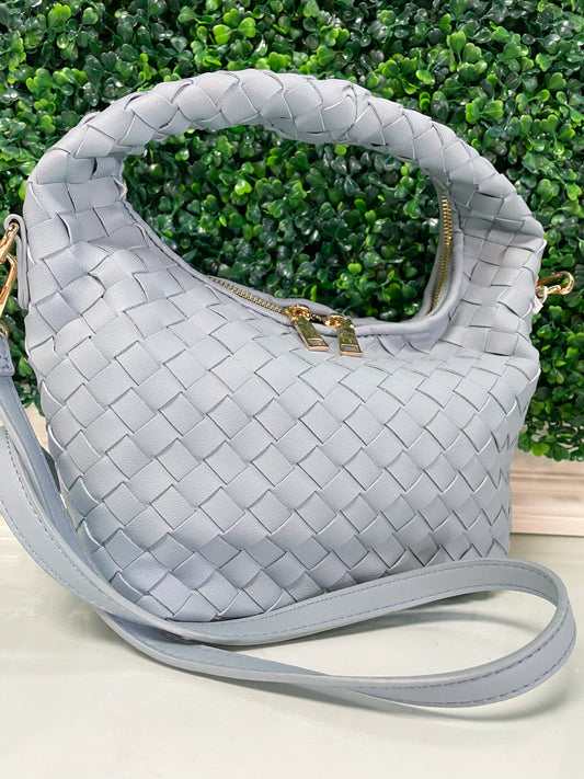 Light blue purse with crossbody strap, woven exterior design, and gold zipper