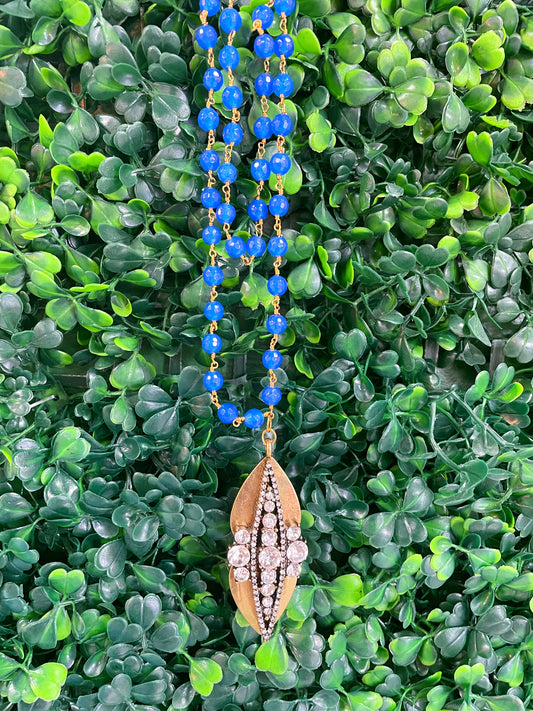 Blue beaded necklace with a gold rhinestone statement piece