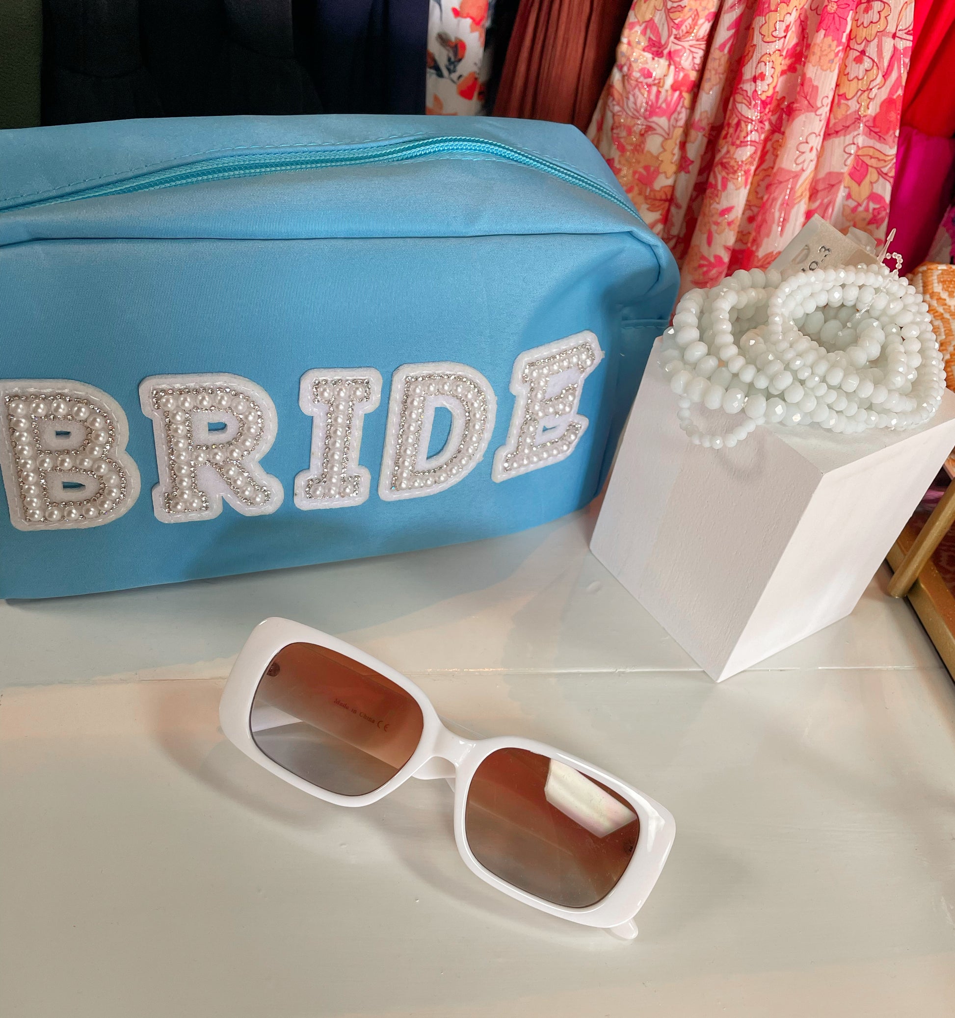 Tiffany blue zippered nylon pouch with the word 'bride' embroidered in white varsity letters on the outside of the pouch.