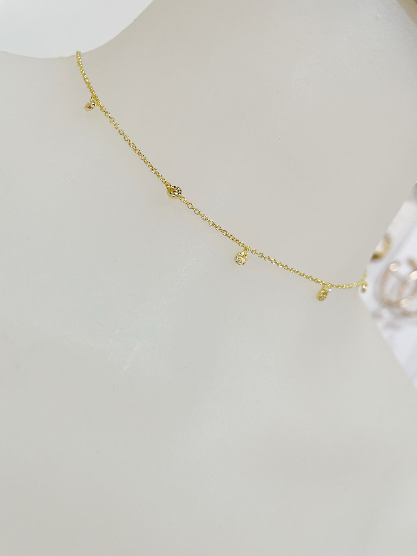 Dainty adjustable gold choker with 5 slightly hammered mini discs around the front of the necklace