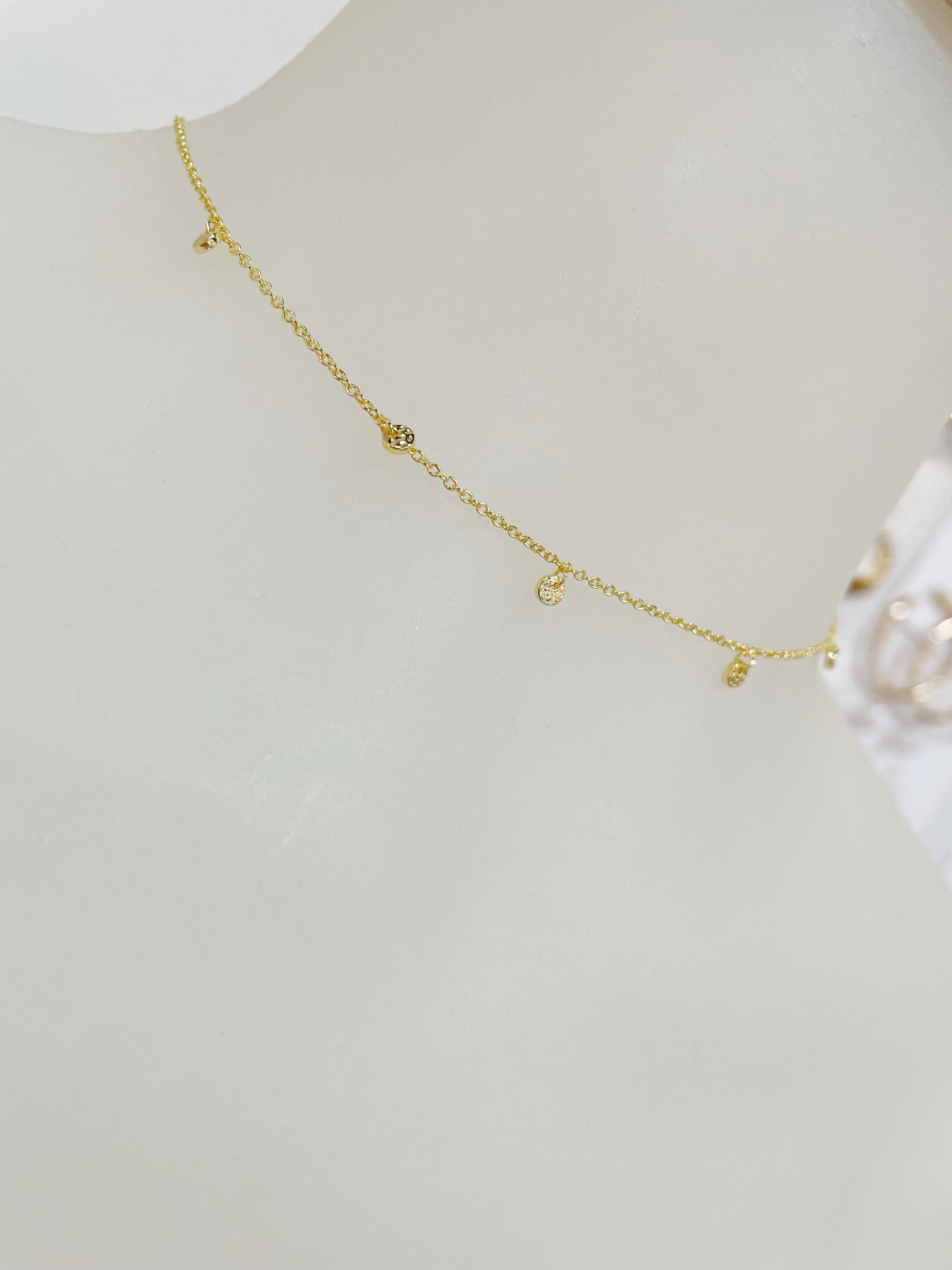 Dainty adjustable gold choker with 5 slightly hammered mini discs around the front of the necklace