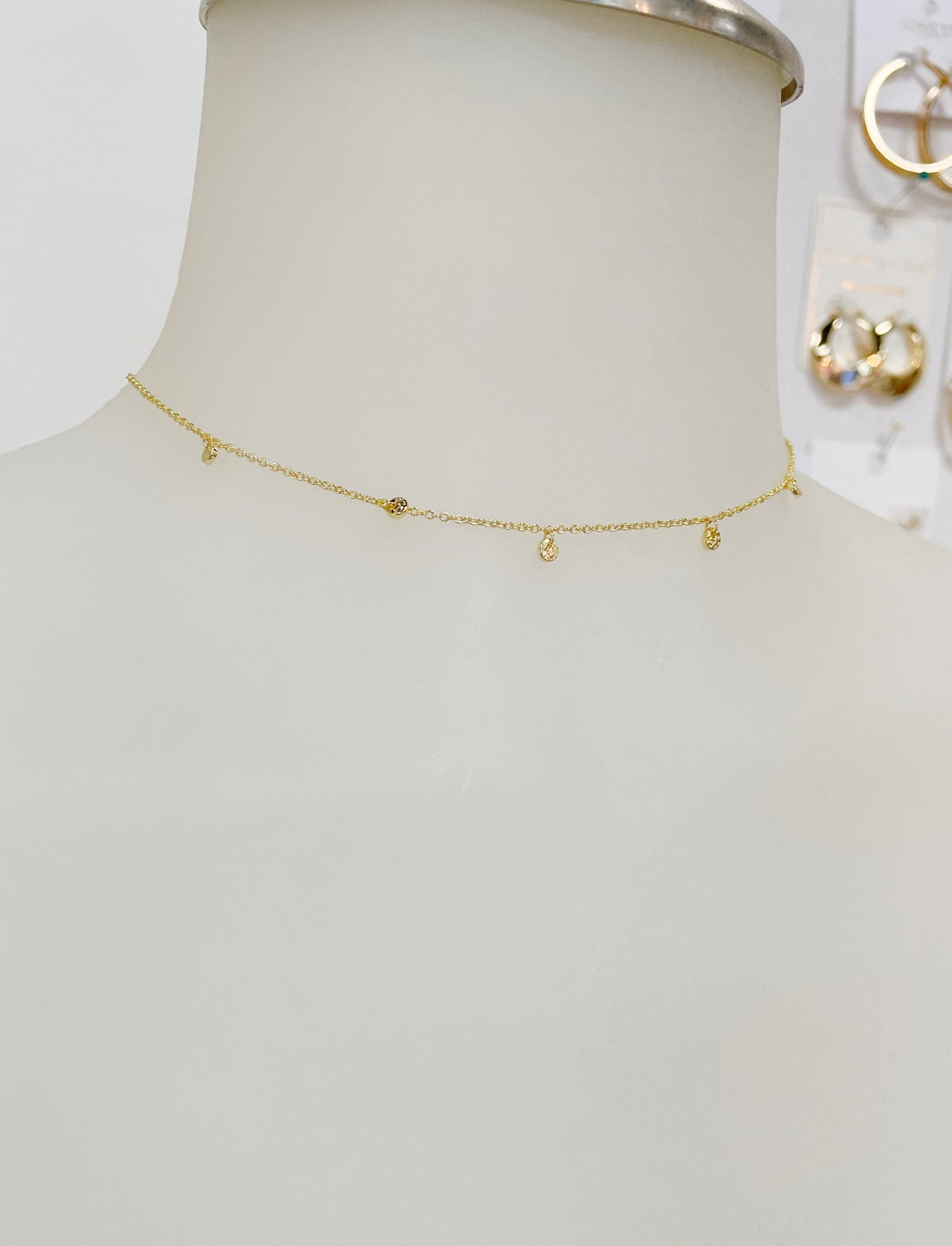 Dainty adjustable gold choker with 5 slightly hammered mini discs around the front of the necklace