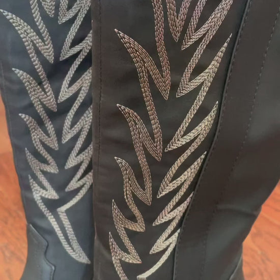 Tall black cowboy boots with embroidered detailing
