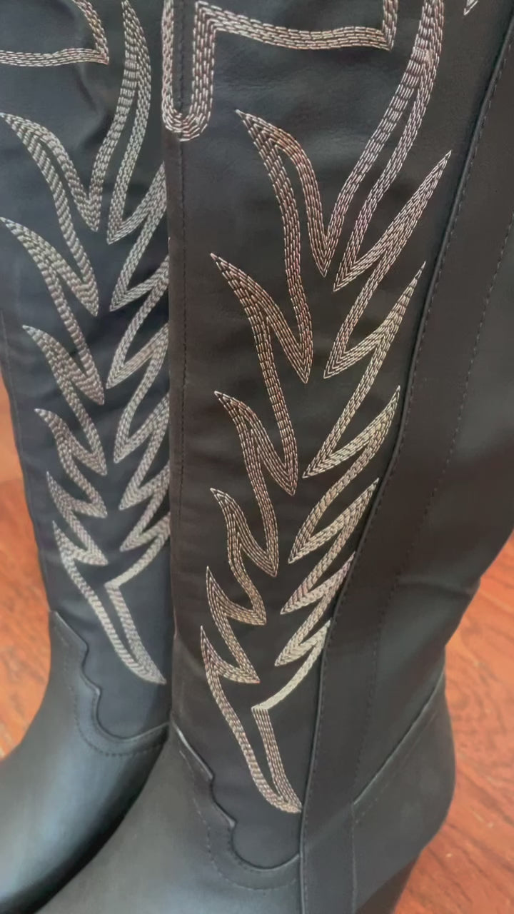 Tall black cowboy boots with embroidered detailing