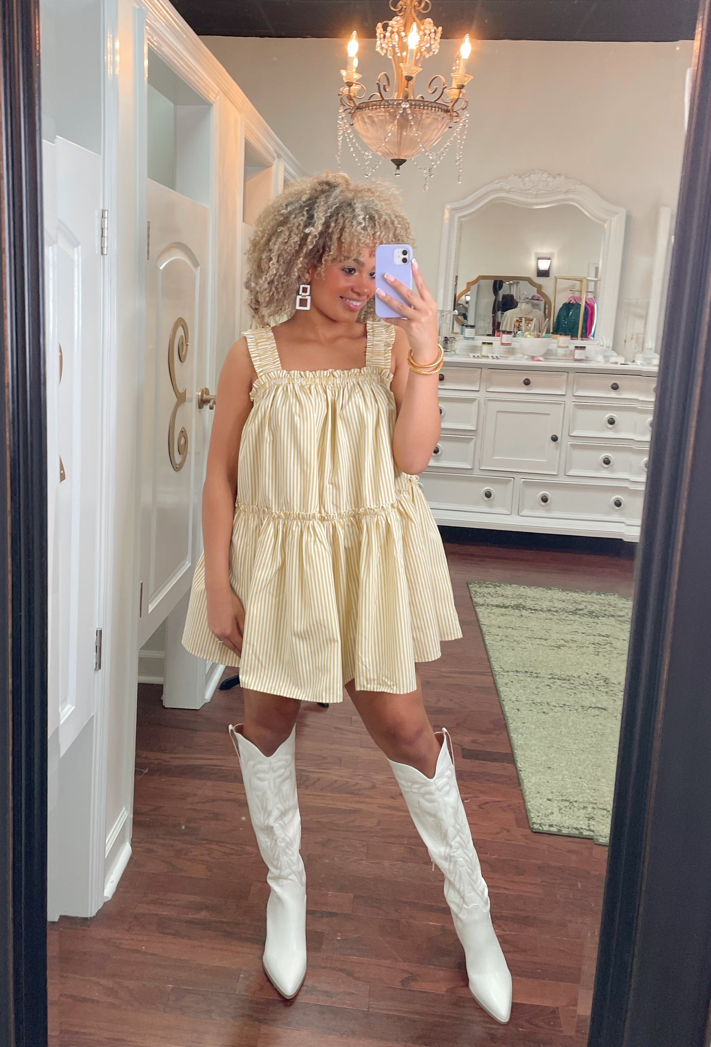 Tall white cowboy boots with embroidered detailing paired with white and yellow striped dress