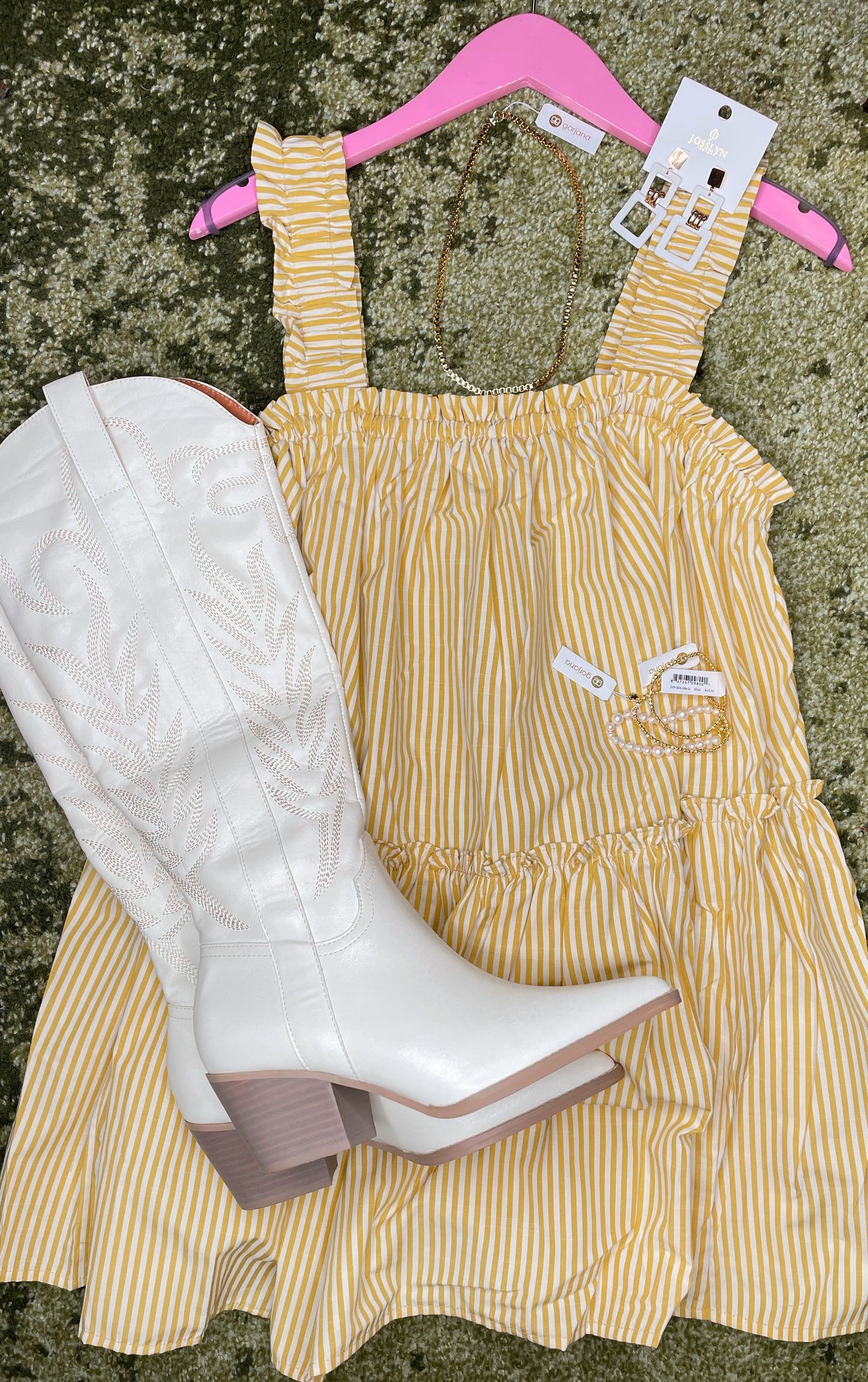 Tall white cowboy boots with embroidered detailing paired with white and yellow striped dress